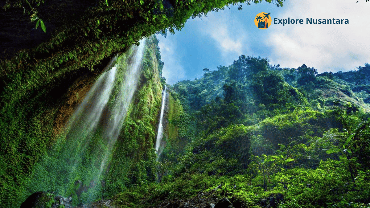 Air Terjun Madakaripura dengan tebing tinggi dan kabut tipis di sekelilingnya