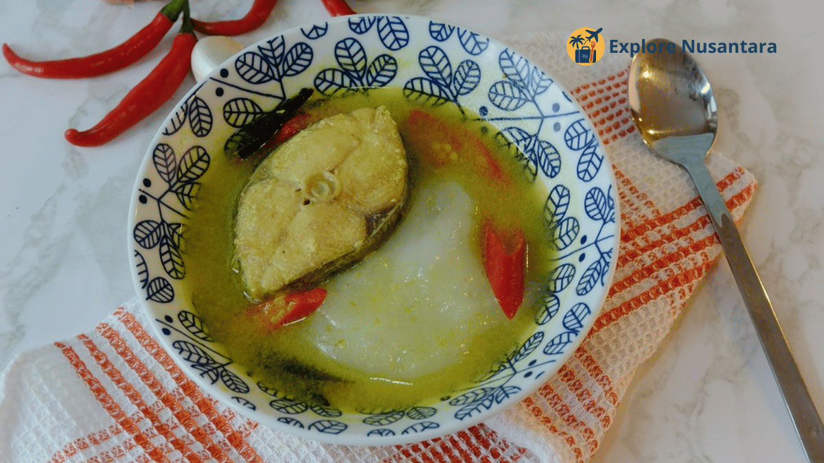 Makan khas kampung halaman Papeda khas Papua dengan ikan kuah kuning di atas piring kayu