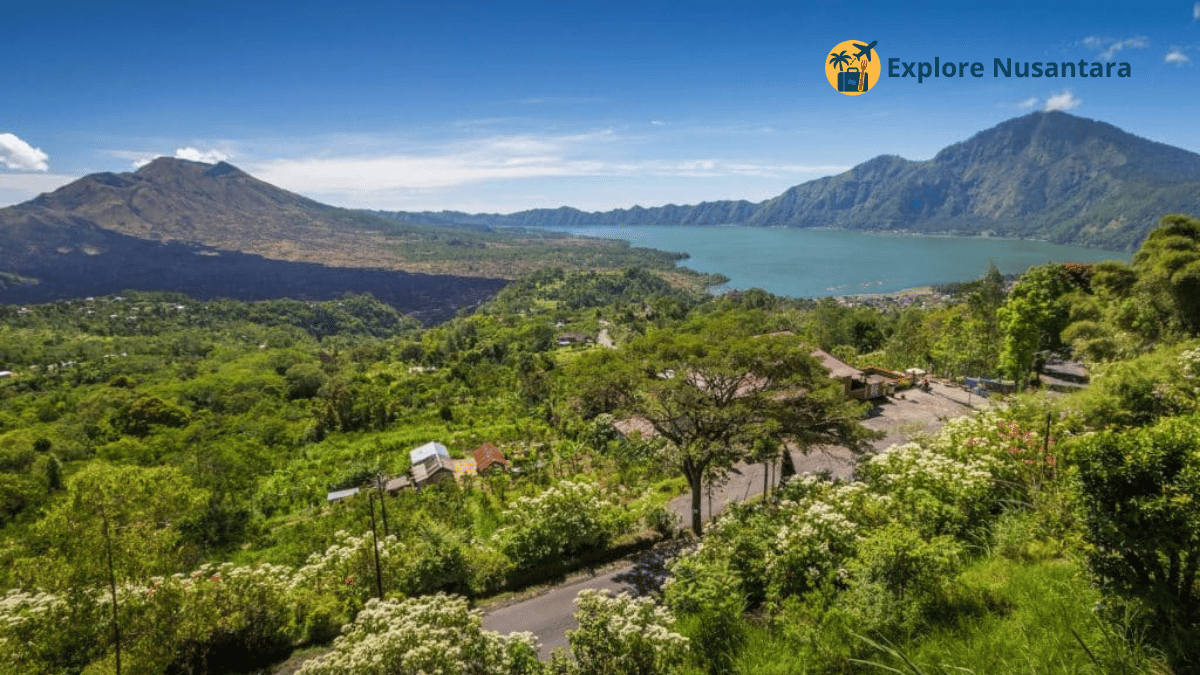 Mobil melintasi jalur pegunungan dengan latar Danau Batur di Kintamani dan terasering sawah Karangasem